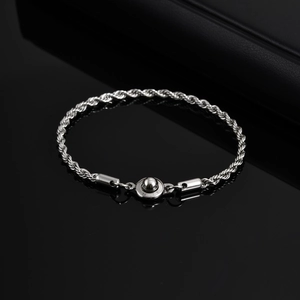 Detail of silver stainless steel rope chain bracelet with unique spherical clasp on black background