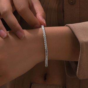 Elegant silver stainless steel wheat chain bracelet for women shown on a model's wrist