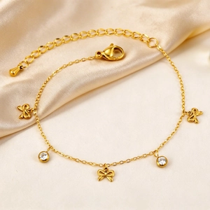 Gros plan du bracelet plaqué or 18K avec nœuds et zircons sur un tissu en soie