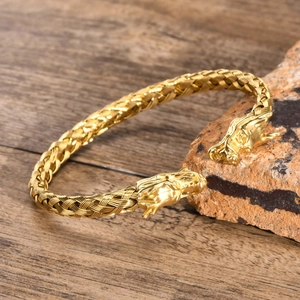Dettaglio delle teste di drago dorate sul bracciale in acciaio titanio intrecciato