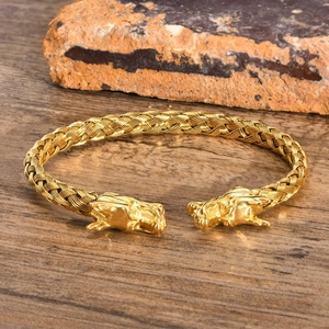 Dettaglio del bracciale intrecciato in acciaio inossidabile dorato con teste di drago