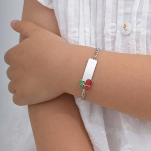 Macro shot of stainless steel child bracelet with cherry charm and engravable identity plate