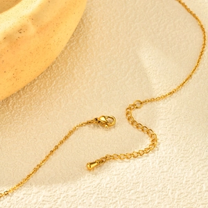 Dettaglio di una chiusura a moschettone placcata oro 18K con catena regolabile su collana