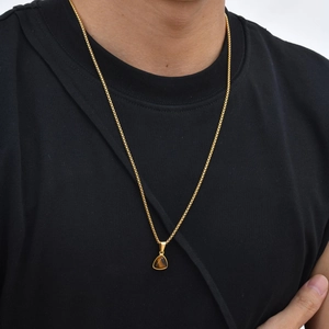 Detailopname van model met gouden roestvrijstalen ketting met een tijgeroog steen hanger