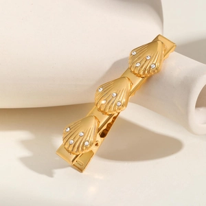 Close-up of golden shell hair clip with pearls and sparkling rhinestones for women