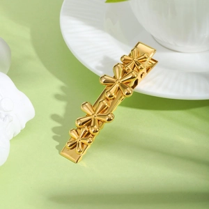 Detailed close-up of a gold-plated flower hair clip with a minimalist metal finish