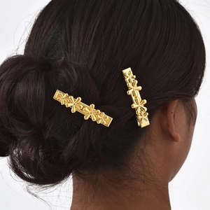 Golden flower hair clips shown on model hair for size and elegant styling