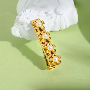 Golden flower hair clip with white pearls and stainless steel finish on art background