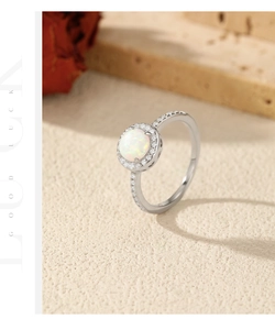 Close-up of S925 silver ring featuring a round white opal stone and small pavé diamonds