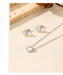 Polished S925 silver heart jewelry set with sparkling crystals on elegant stone background