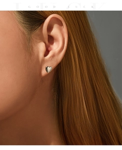 Close-up of S925 silver heart stud earrings with sparkling pavé zircons on model ear