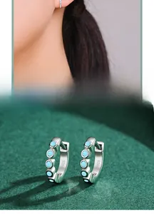 Close-up of S925 sterling silver hoop earrings set with round turquoise stones
