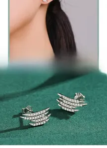 Macro shot of 925 sterling silver ear studs with layered zircon pavé wings
