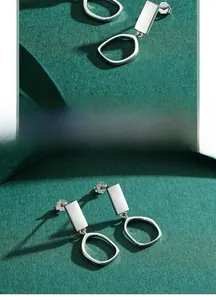 Detailed view of S925 sterling silver stamp on minimalist geometric dangle earrings