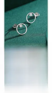 Detail of silver geometric circle stud earrings with a sparkling round zircon stone