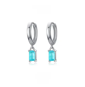 Macro detail of S925 sterling silver hoop earrings with rectangular blue-green gemstone