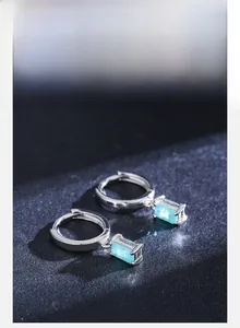 Macro detail of S925 sterling silver hoop earrings with rectangular Paraiba blue tourmaline