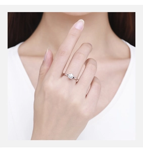 Detailed close-up of a minimalist silver solitaire ring with a round brilliant cut moissanite