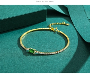 Macro detail of S925 sterling silver gold bracelet with emerald green zircon gemstone
