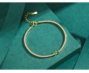 Close-up of S925 silver gold bracelet with emerald zircon and pavé white stones