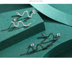 Macro shot of silver and black snake stud earrings with micro-inlaid sparkling gemstones
