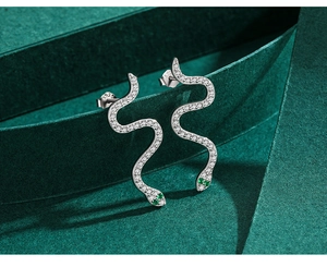 Detailed close-up of S925 sterling silver snake earrings with white and green zircons