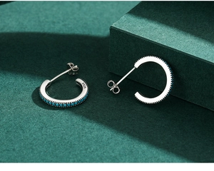 Macro shot of S925 sterling silver C-shaped earrings with turquoise beads and hallmark