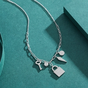 S925 silver necklace with micro-pave charms including key and lock on paper background