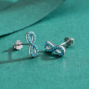 S925 sterling silver infinity stud earrings with pavé turquoise stones on green texture