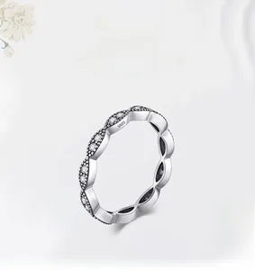 Macro shot of S925 sterling silver eternity band featuring wavy edges and pavé set stones