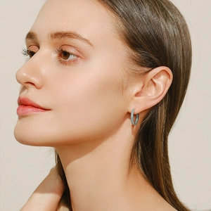 Classic S925 sterling silver hoop earrings with turquoise stones on a model