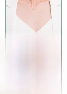 Détail du collier en argent S925 avec pendentif mini cœur doré sur tissu vert
