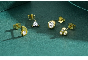 Détails macro de boucles d'oreilles en argent S925 plaqué or avec pierres et poinçons