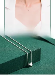 Détail du collier cœur en argent s925 sur coffret vert et vue portée par un mannequin