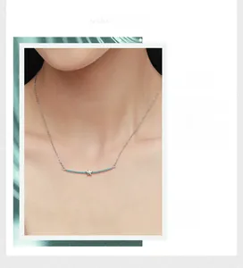 Makrodetail eines silbernen Sternanhängers mit hellblauem strukturiertem Rohr an einer Kette