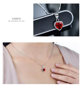 Détail d'un collier en argent avec pendentif rubis en forme de cœur et halo de diamants