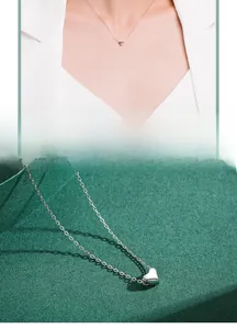 Détail d'un collier pendentif cœur en argent sterling sur un fond à texture élégante