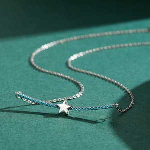 Minimalistische S925 Sterling Silber Sternenkette mit Türkissteinen auf grünem Hintergrund