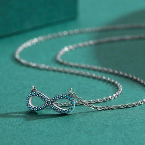 S925 sterling silver infinity pendant necklace with turquoise stones on green background