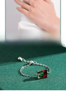 Macro detail of adjustable chain ring with red and green gradient rectangular gemstone