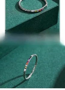 Macro detail of silver ring featuring scale textures and multi-colored gemstone inlays