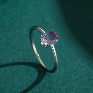 S925 sterling silver ring with oval pink tourmaline gemstone on dark green background