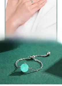 Macro detail of a minimalist silver ring featuring a round light blue turquoise gemstone