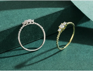 Macro shot of silver and gold rope style rings with three inlaid cubic zirconia stones