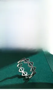 Macro shot of retro 925 sterling silver hollow geometric ring on dark green background