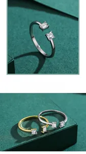 Detail of adjustable silver and gold rings with geometric emerald and princess cut stones
