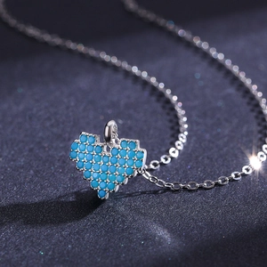 Collier cœur pixel en argent S925 avec pierres turquoise sur fond sombre étoilé