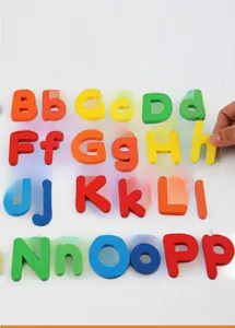 Close-up of hand holding a small wooden 'h' from a colorful alphabet learning set