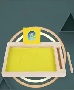 Détail d'un plateau de sable en bois avec stylet et carte pour apprendre à écrire