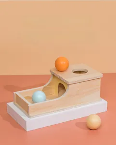 Detail of Montessori object permanence box with colorful wooden balls for toddlers